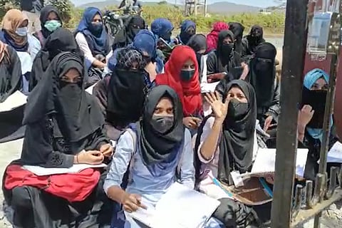 Students in hijab sitting in protest 
