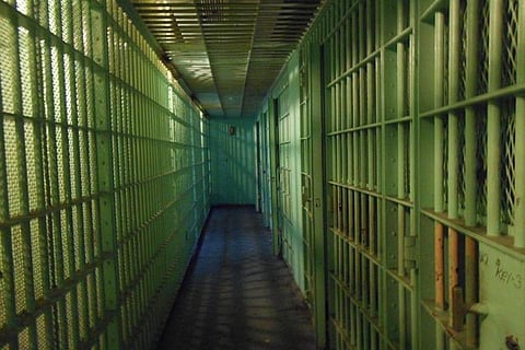 Narrow corridor in a prison with with cells on either side