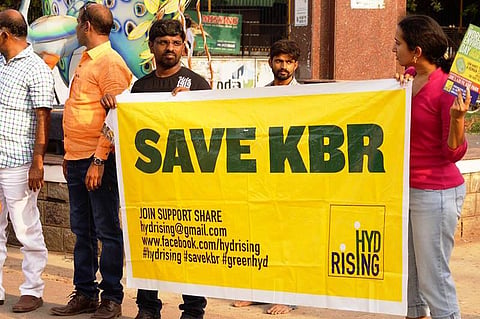 Protesters holding a poster that reads 'Save KBR'