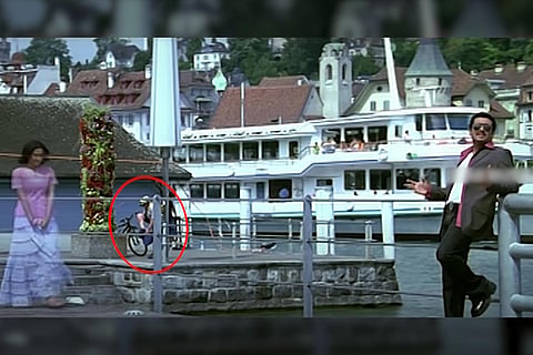 An image from Sillunu Oru Kadhal featuring Suriya and Jyotika, while a man removing his pants is seen in the background.