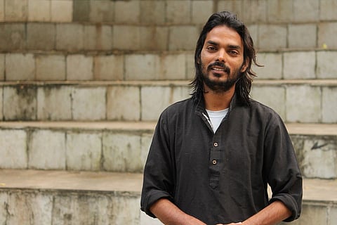 Somnath Waghmare in a black shirt standing on stairs