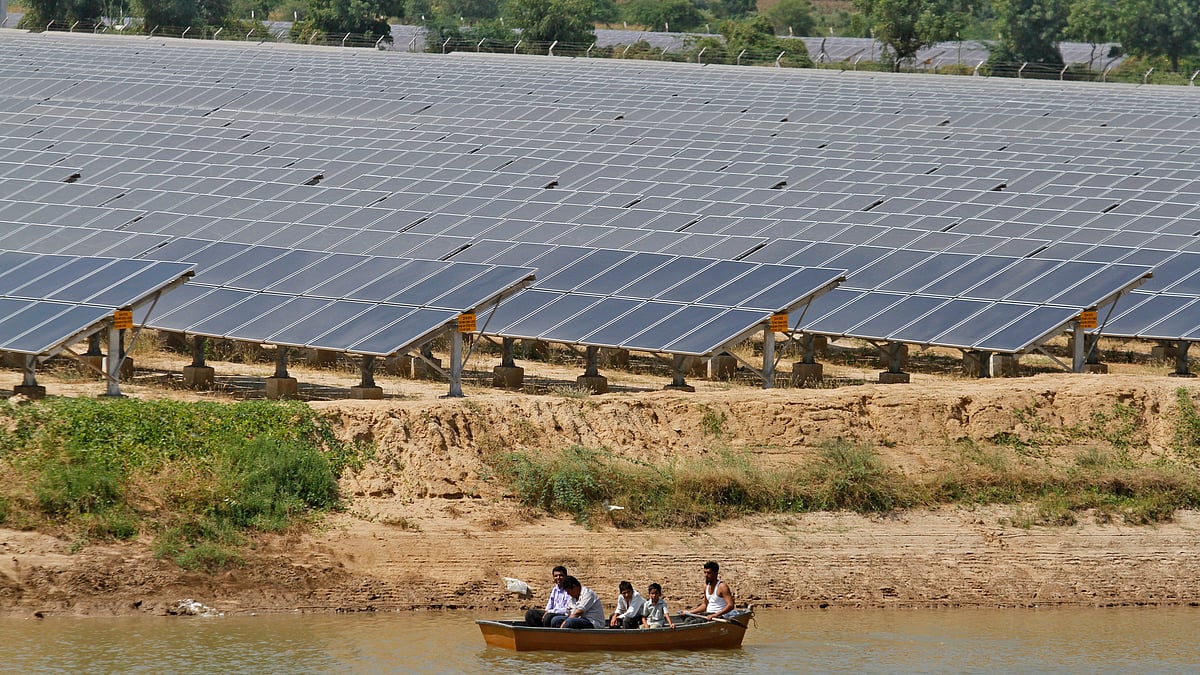 Security personnel sit in a boat as they patrol the premises of solar farm in Gujarat. 