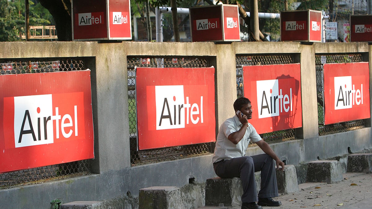 A man talks on a mobile phone in front of advisements of Bharti Airtel in the eastern Indian city of Siliguri. (Photo: Reuters)