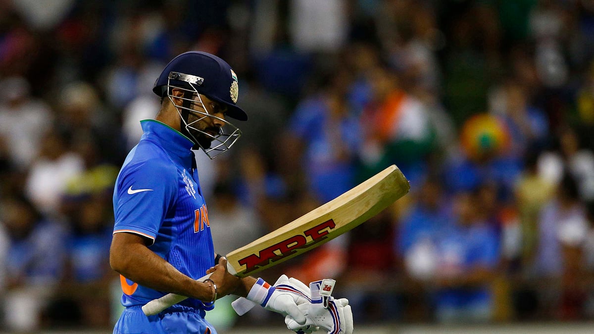 India’s batsman Virat Kohli looks at his bat as he walks off the field after he was caught out by West Indies Marlon Samuels during their Cricket World Cup match in Perth. (Photo: Reuters)