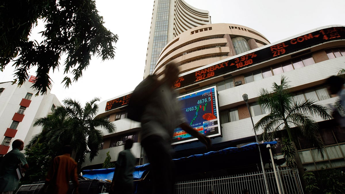 People walk pass the Bombay Stock Exchange (BSE) building displaying India’s benchmark share index on its facade, in Mumbai.&nbsp;