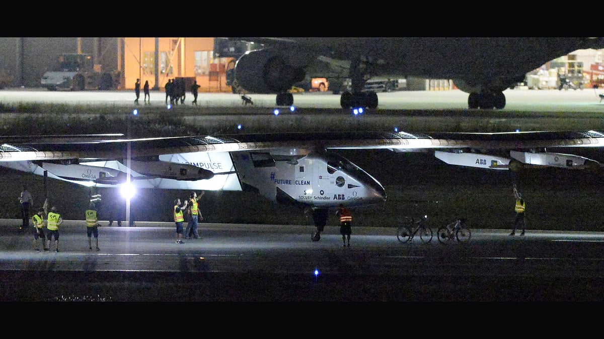 The Solar Impulse 2 project staff members gather around the aircraft as it lands the Nagoya Airport in Japan. (Photo: AP)
