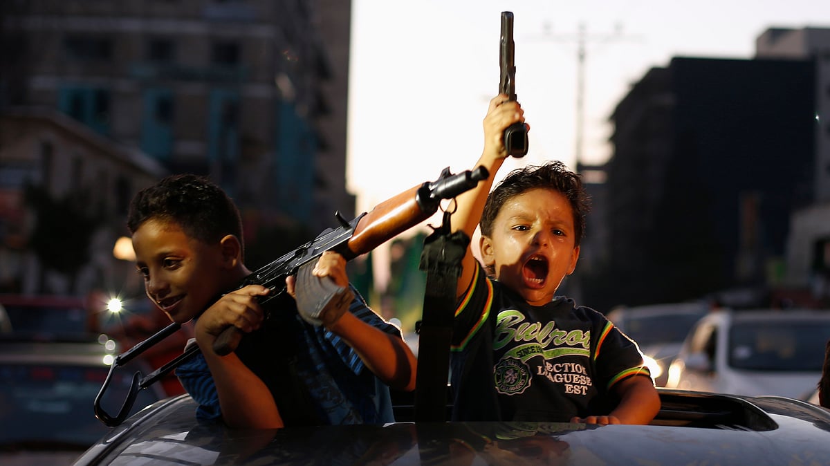Palestinian children hold guns as they celebrate with others what they said was a victory over Israel, following a ceasefire in Gaza City August 26, 2014. (Photo: Reuters)