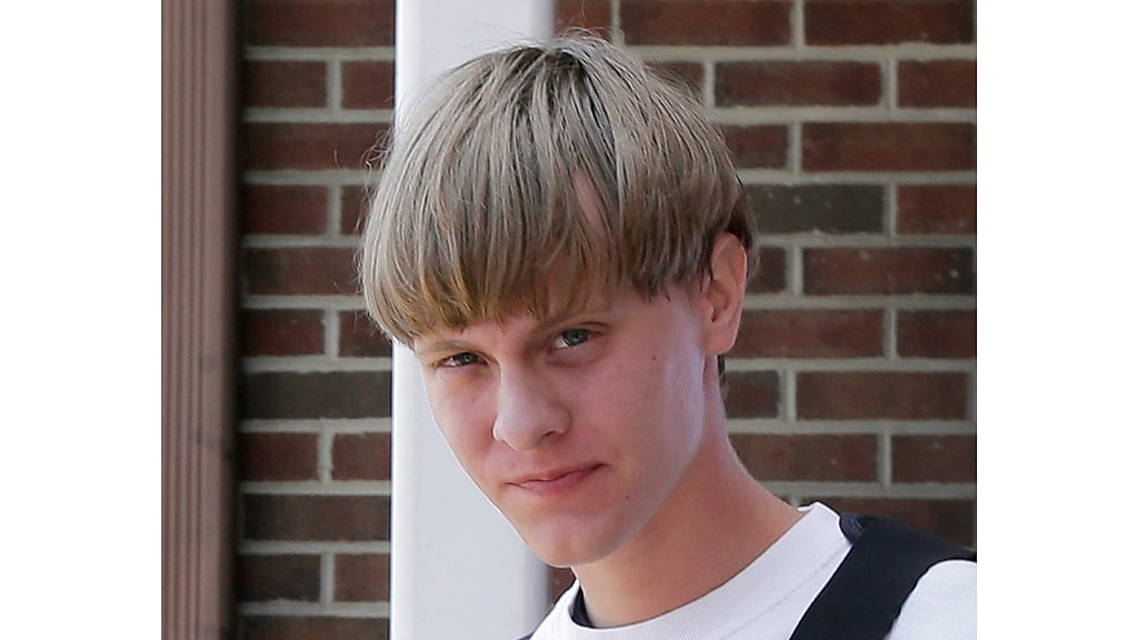 Dylann Storm Roof, 21, appears to be smiling as he is taken out from the Shelby Police Department in North Carolina (Photo: AP)