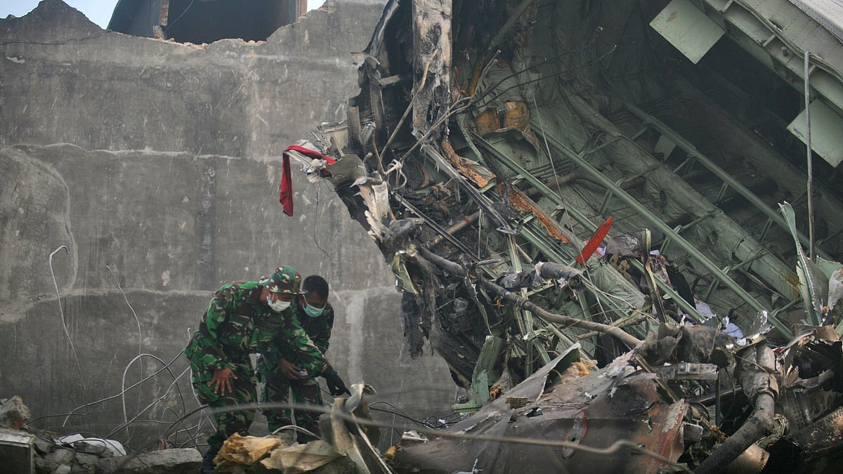 Rescuers search for victims at the crash site where an Indonesian air force transport plane crashed. (Photo: AP)