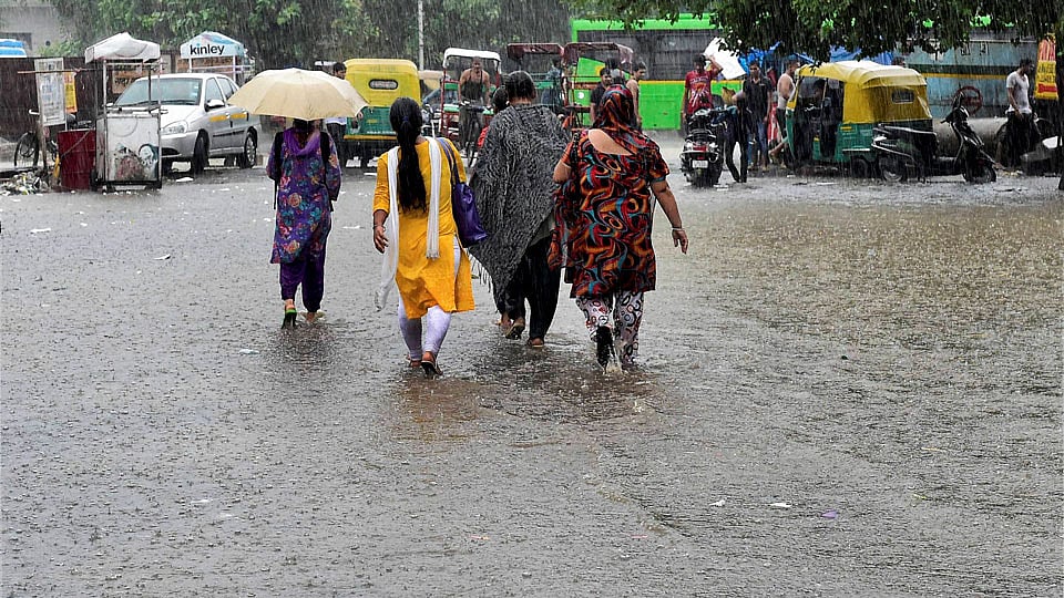 People walk on a water logged street in New Delhi. (Photo: PTI)