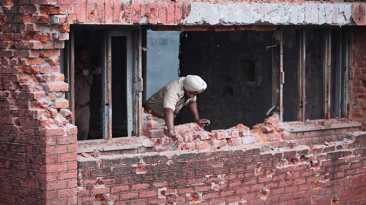 A police officer inspects bullet marks on the building after the terror attack in Dinanagar, Punjab, on Monday, July 27, 2015. (Photo: AP)