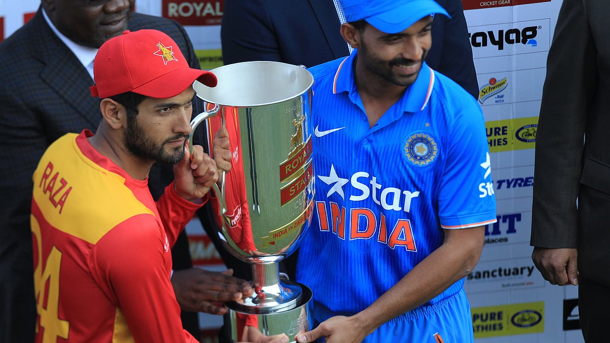 Zimbabwean captain Sikandar Raza, left, and  Indian captain Ajinkya Rahane  share the trophy after Zimbabwe levelled the two match T20 series. (Photo: AP)