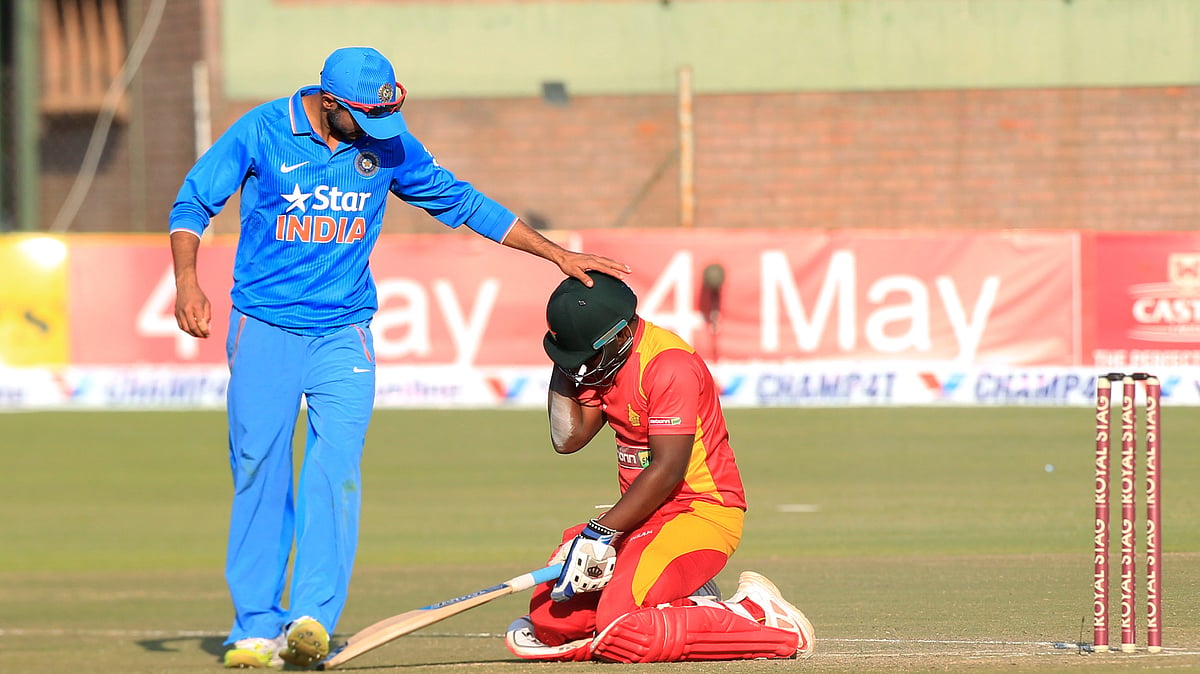 Indian captain  Ajinkya Rahane check on Zimbabwean batsman Prosper Utseya after he fell to the ground during the T20 match against India. (Photo: AP)