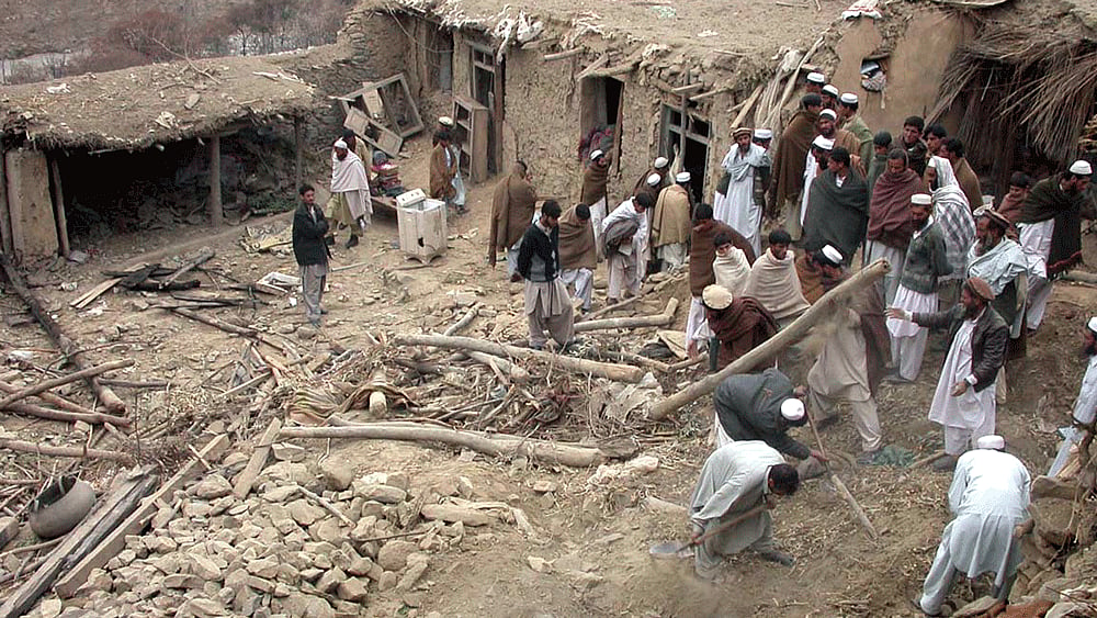 Pakistani tribesmen search a house which was destroyed after a US air strike in Damadola on&nbsp;January 14, 2006. (Photo: Reuters)