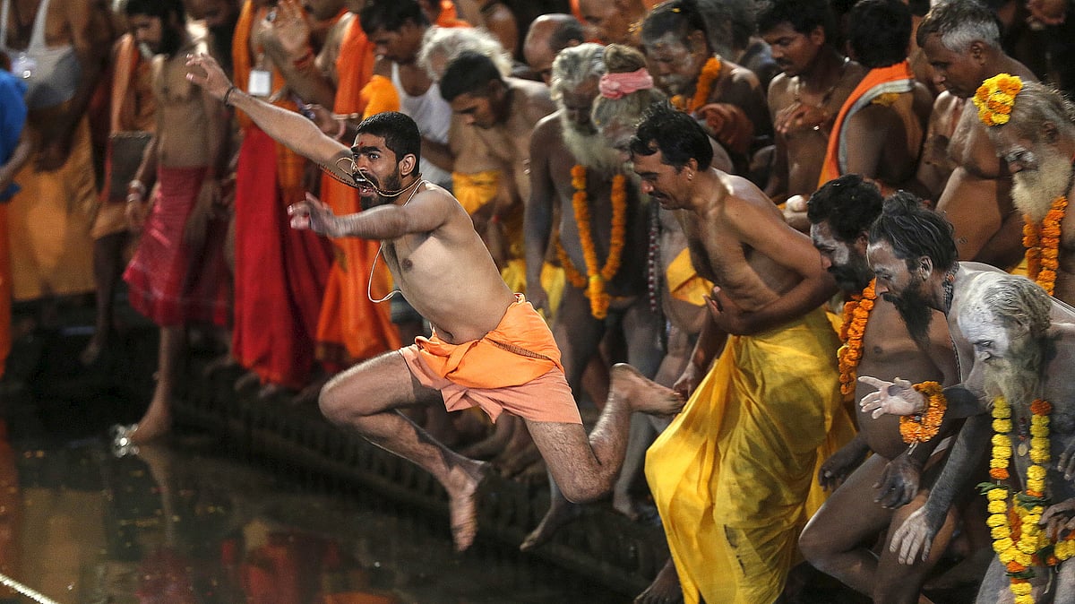 Sadhus jump in a holy pond during the first <i>Shahi Snan</i> (grand bath) at the <i>Kumbh Mela</i> in Trimbakeshwar.