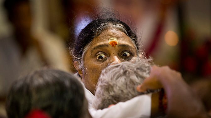 Spiritual guru Mata Amritanandamayi blesses a devotee by hugging him&nbsp;during a prayer meeting. (Photo: AP)