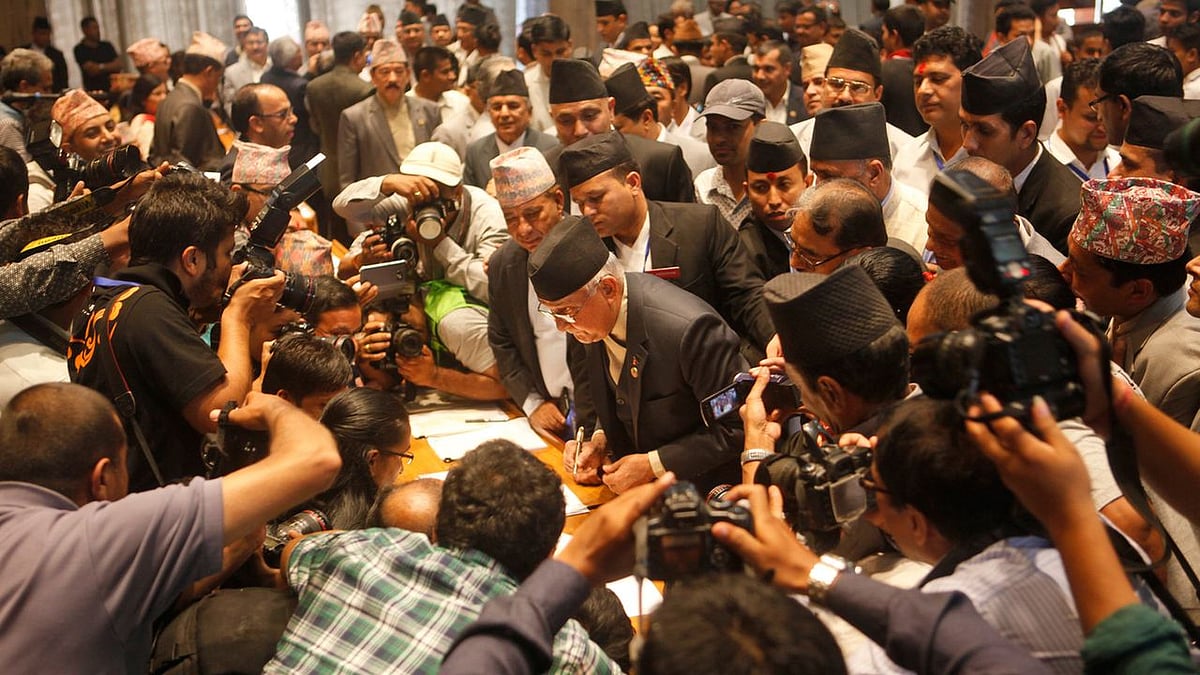 Communist Party of Nepal (Unified Marxist–Leninist) leader KP Oli (center) signs the constitution document. (Photo: AP)