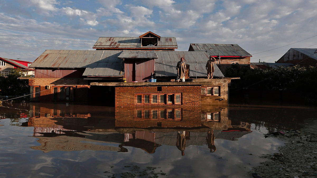 Men standing on the roof of their flooded house as they wait to be rescued by Indian army soldiers, Srinagar,&nbsp;September 2014. (Photo: Reuters) &nbsp;