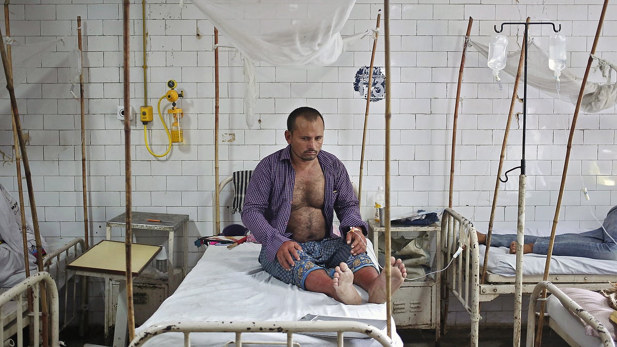 A patient awaits routine check-up as he sits under a mosquito net inside a dengue ward of a government hospital in New Delhi. (Photo: Reuters)