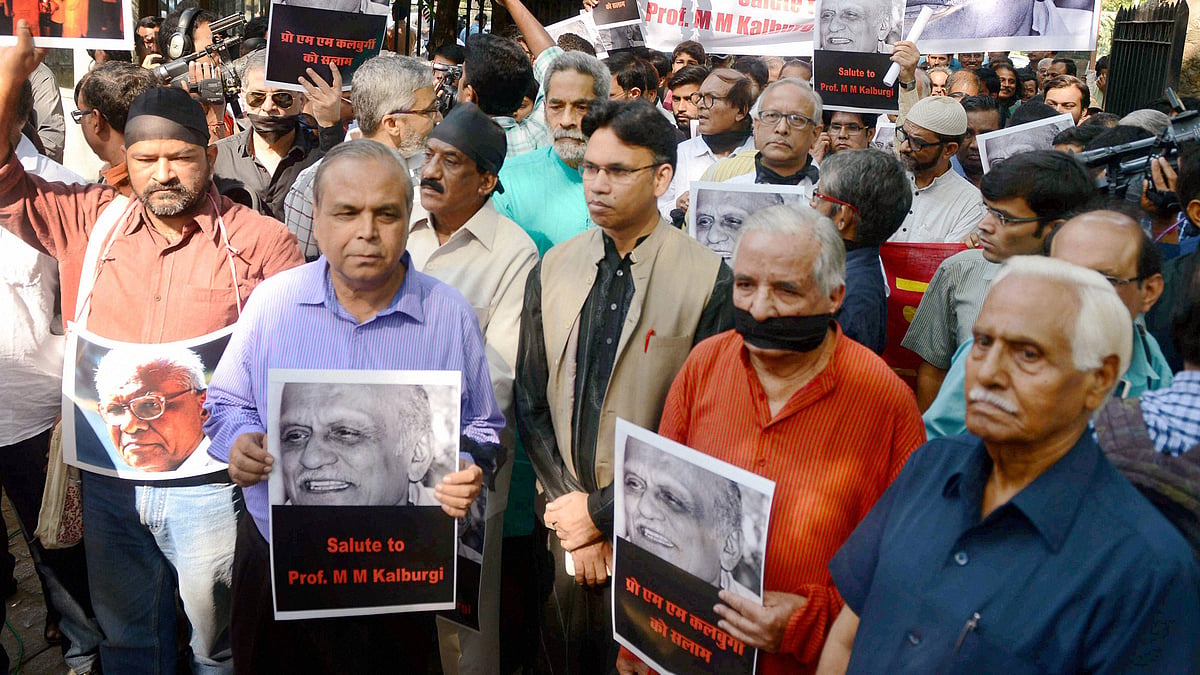 Writers and cultural activists with black gags and arm bands take out a solidarity march in New Delhi on Friday. (Photo: PTI)