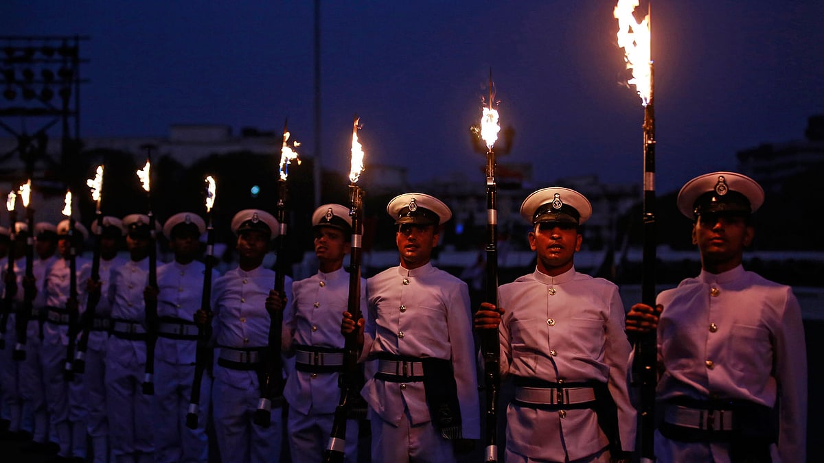 Indian Navy soldiers demonstrate their skills while holding their weapons during Navy Day celebrations 