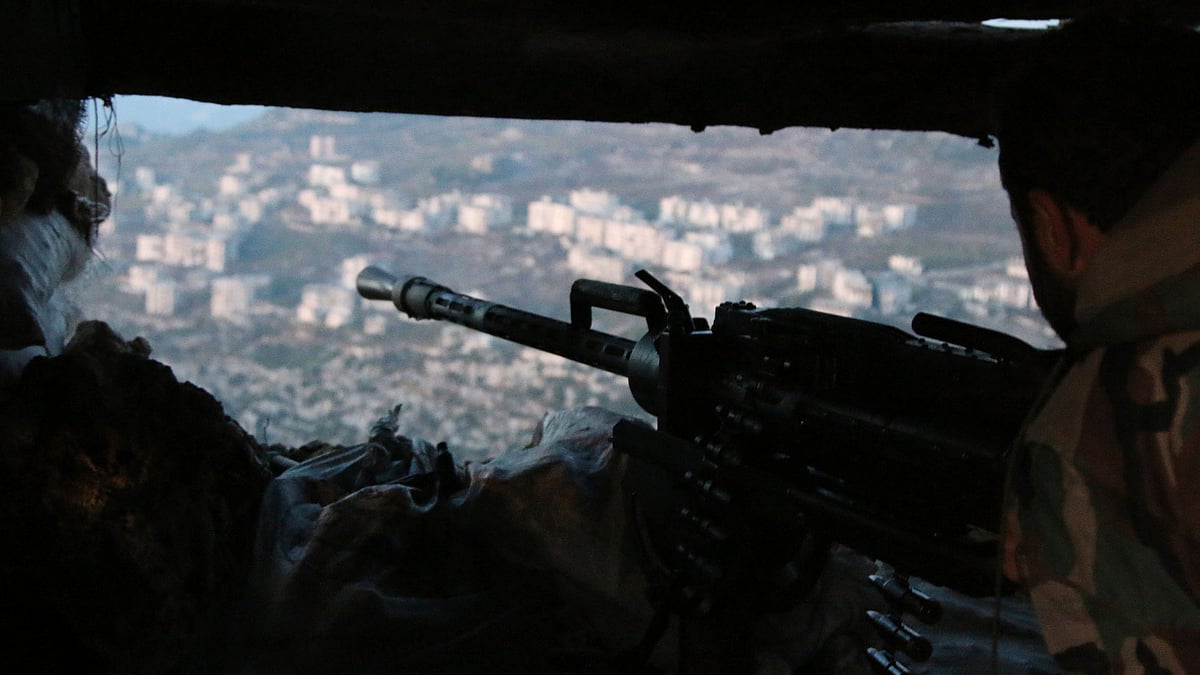 A Syrian army soldier fires a machine gun in Latakia province. (Photo: AP)