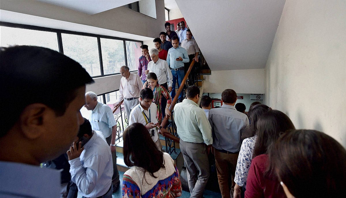 Employees come out of their offices after an earthquake in New Delhi on Monday. (Photo: PTI)