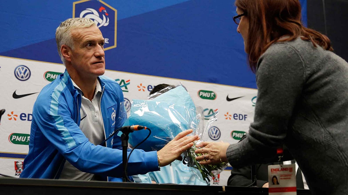 France coach Didier Deschamps receives a bouquet of flowers by journalist during the press conference. (Photo: Reuters)