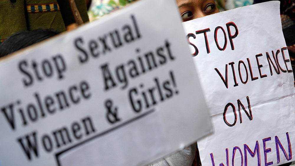 A demonstrator holds placards during a protest in New Delhi on December 29, 2012. (Photo: Reuters)