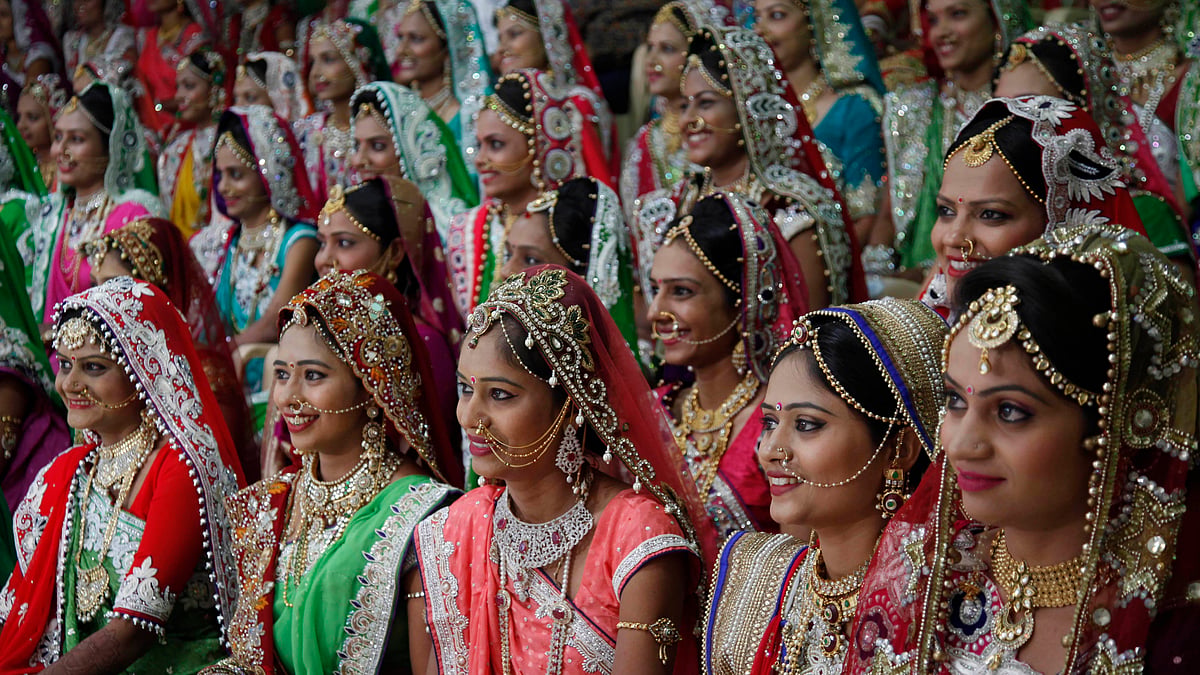 Brides sit for a group photo before a <a href="http://www.thequint.com/photos/2015/12/07/in-pics-surat-businessman-hosts-mass-wedding-for-fatherless-women">mass wedding</a> hosted by a diamond trader in Surat on Sunday, where 151 young couples tied the knot. (Photo: AP/Ajit Solanki)