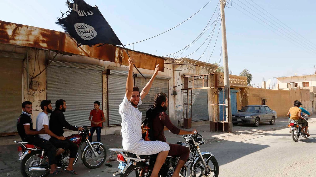 A resident waves an Islamic State flag in Syria. (Photo: Reuters) &nbsp; &nbsp;  