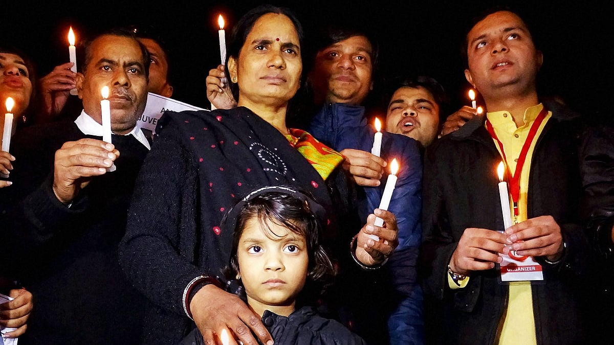 Asha Devi, the mother of December 16 gangrape victim Jyoti Singh also known as Nirbhaya, holds a candle at the vigil held for her daughter. (Photo: PTI)