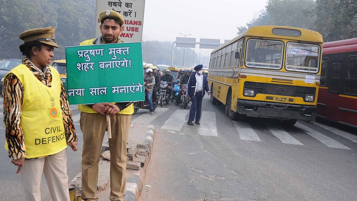Civic Defence Volunteers stand on Delhi roads holding placards on Day 4 of the implementation of the odd-even formula in Delhi. (Photo: IANS) 