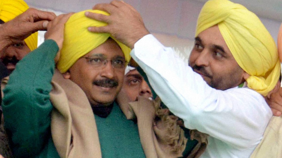 Delhi Chief Minister and AAP convener Arvind Kejriwal is presented a turban by party MP Bhagwant Maan during a party rally in Muktsar. (Photo: PTI)