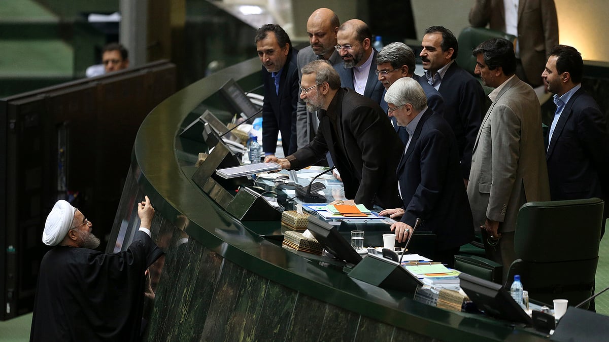In this file photo, Iranian President Hassan Rouhani, left,
presents a draft of the country’s new budget and sixth development plan. (Photo: AP) 
