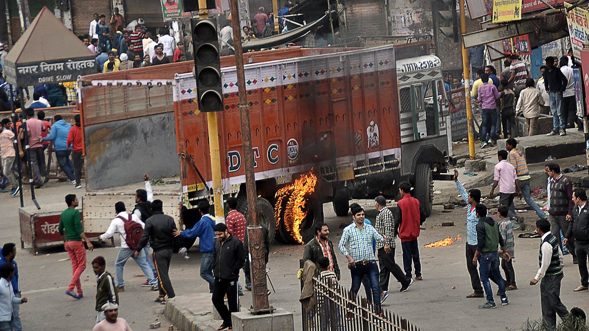 Protesters vandalise and damage vehicles during a pro-caste quota protest in Rohtak, 70 kilometres from New Delhi. (Photo: AP)