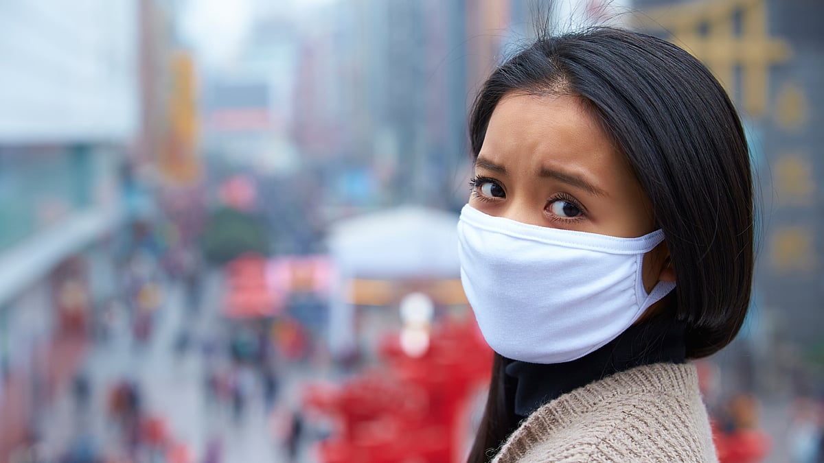 A young woman wears a mask for protection from pollution. (Photo: iStockphoto)