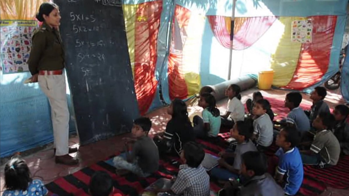 Cops in Madhya Pradesh, India, have taken up the responsibility of educating slum kids in a bid to steer them away from a life of crime. (Photo Courtesy: AP/Caters News/The Hindustan Times screengrab)