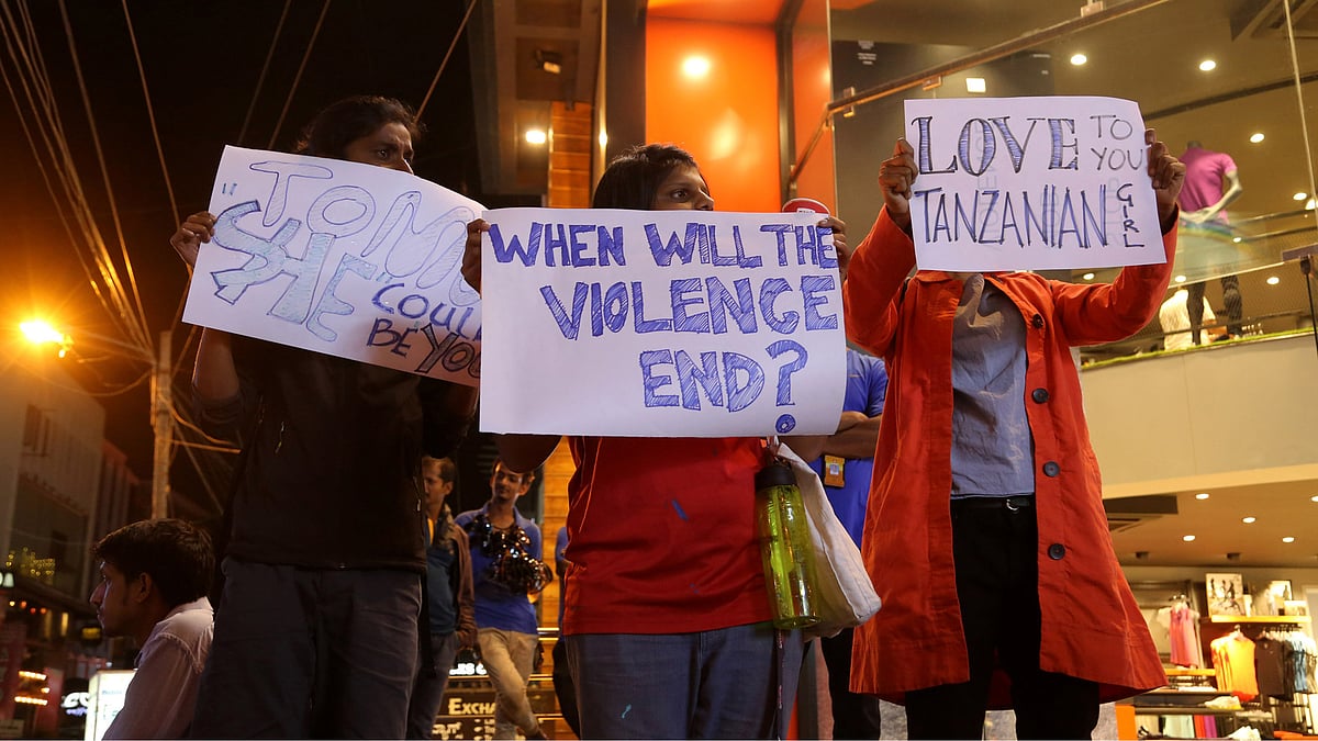 Students holding placards in support of the Tanzanian girl in Bengaluru. (Photo: AP)