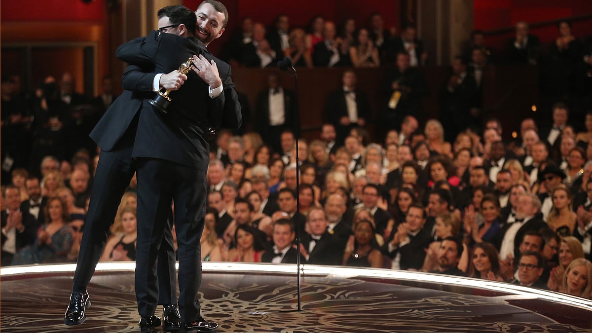 Sam Smith and Jimmy Napes hug it out after winning the Best Original Song at the Oscars. (Photo: AP)