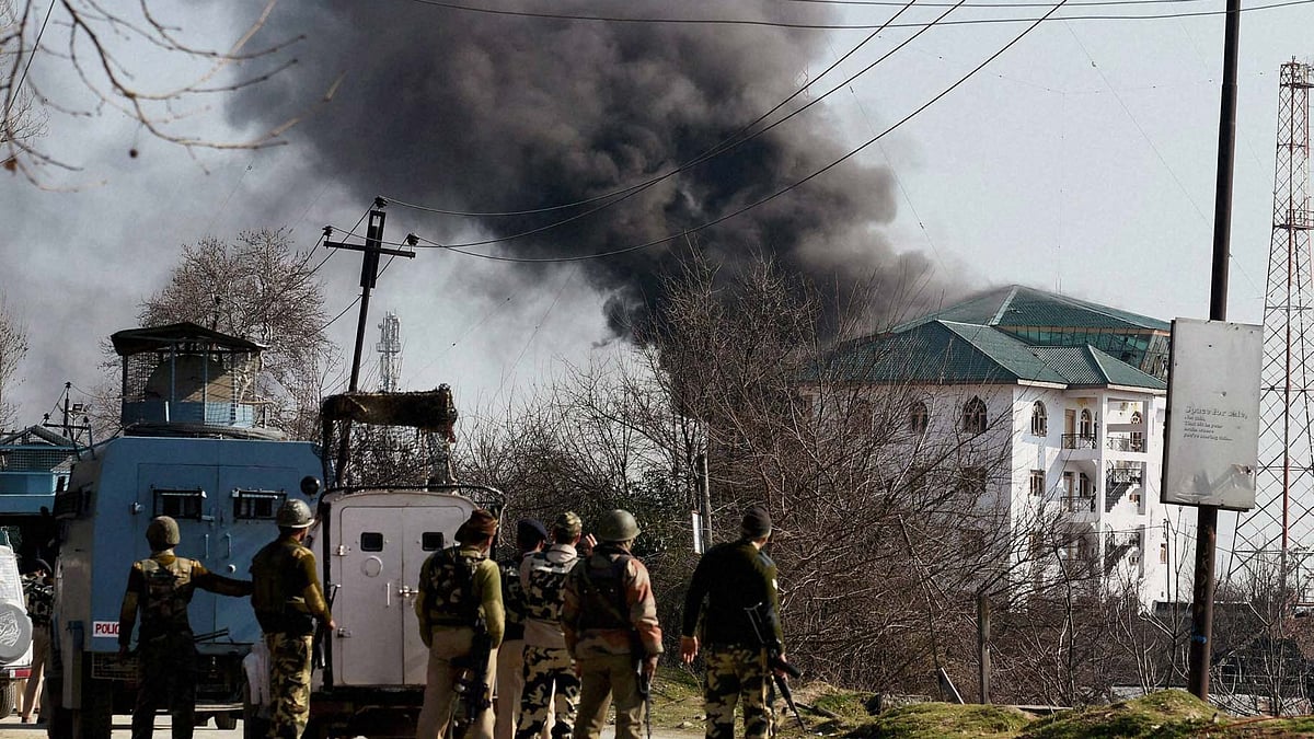 Security forces personnel take position outside the JKEDI building where militants have reportedly taken refuge. (Photo: PTI)