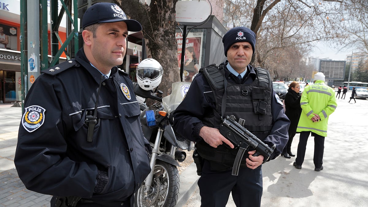 Security officials stand as they check cars and suspected persons on busy Tunali Hilmi Street. (Photo: AP)