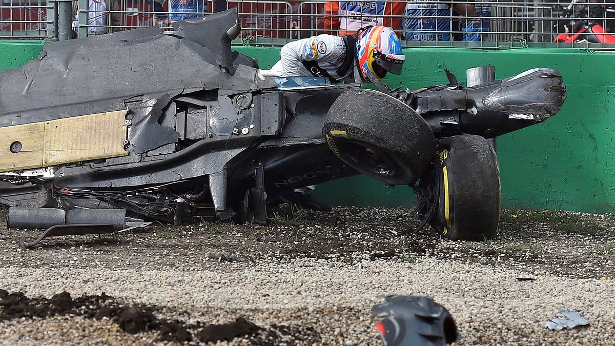 Fernando Alondo climbs out  of his wrecked car after he collided with Haas driver Esteban Gutierrez of Mexico during the Australian F1 Grand Prix. (Photo: AP)