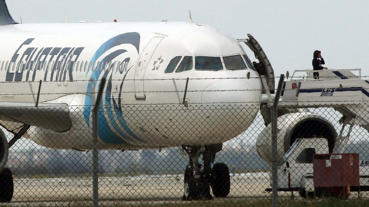An official makes a call from the ramp of a hijacked Egyptair A320 Airbus at Larnaca Airport, Cyprus. (Photo: Reuters)