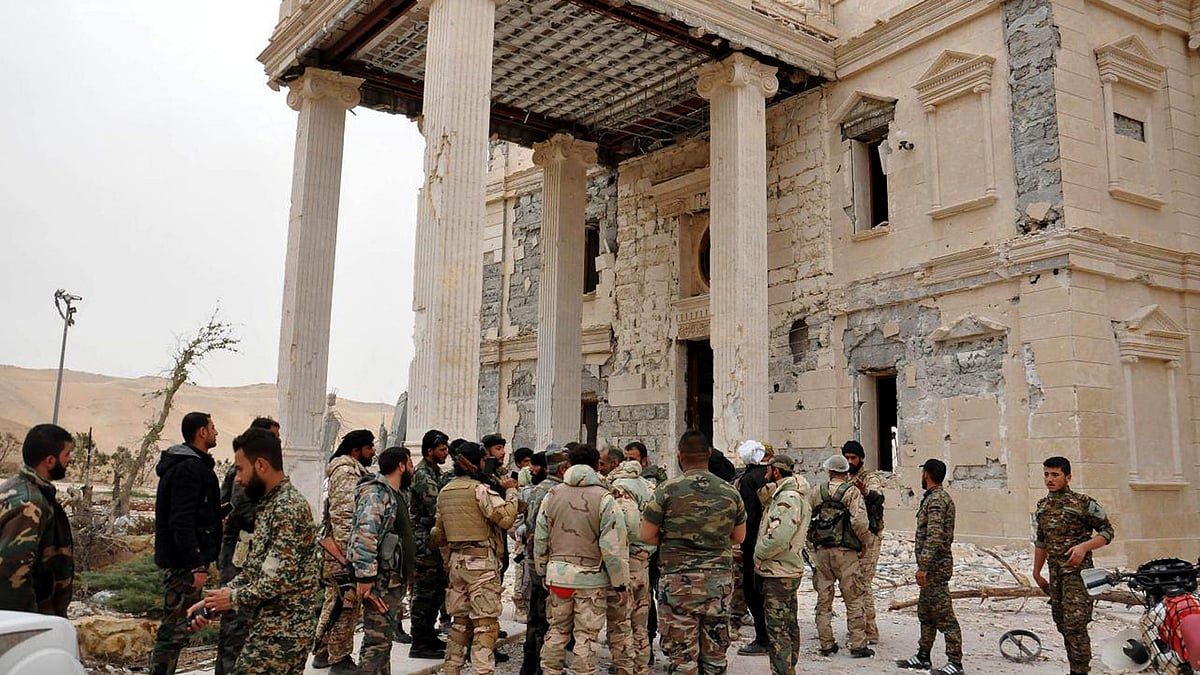 Soldiers gather outside a damaged palace, in Palmyra, central Syria. (Photo: AP)
