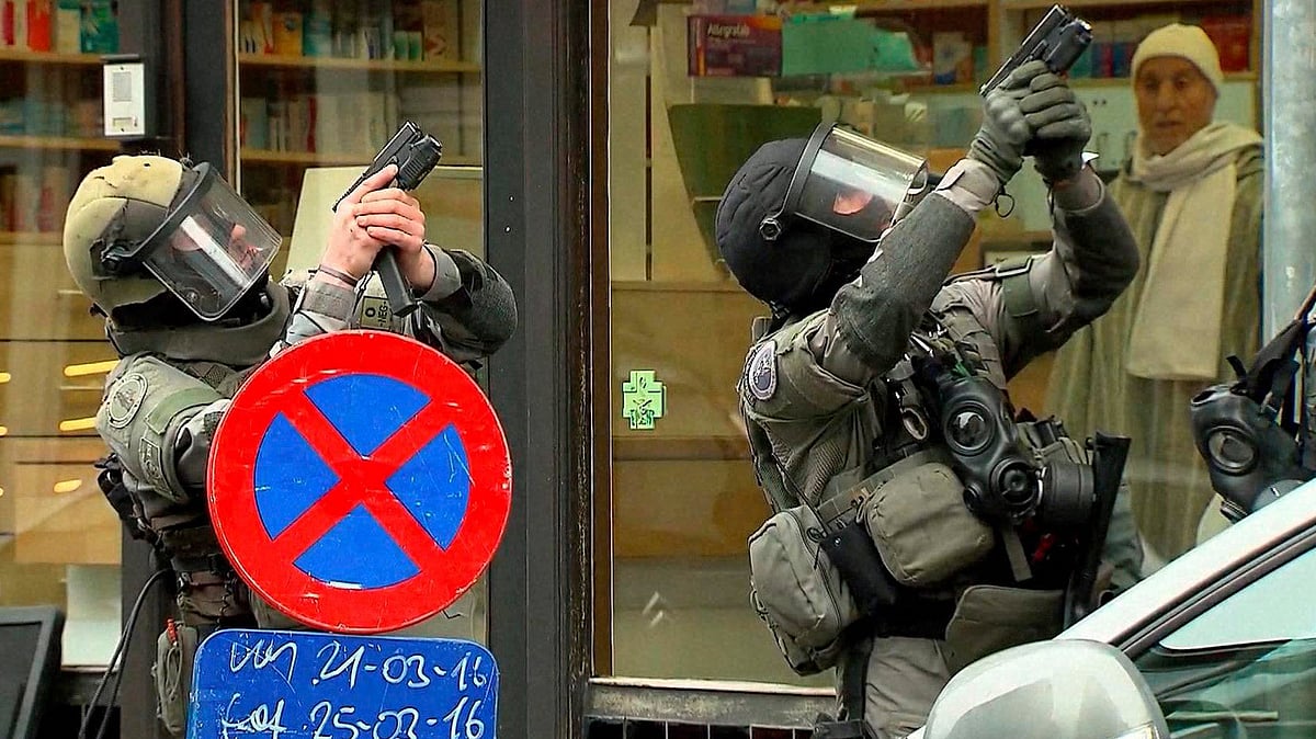In this framegrab taken from VTM, armed police officers take part in a raid in the Molenbeek neighborhood of Brussels, Belgium, Friday March 18, 2016.