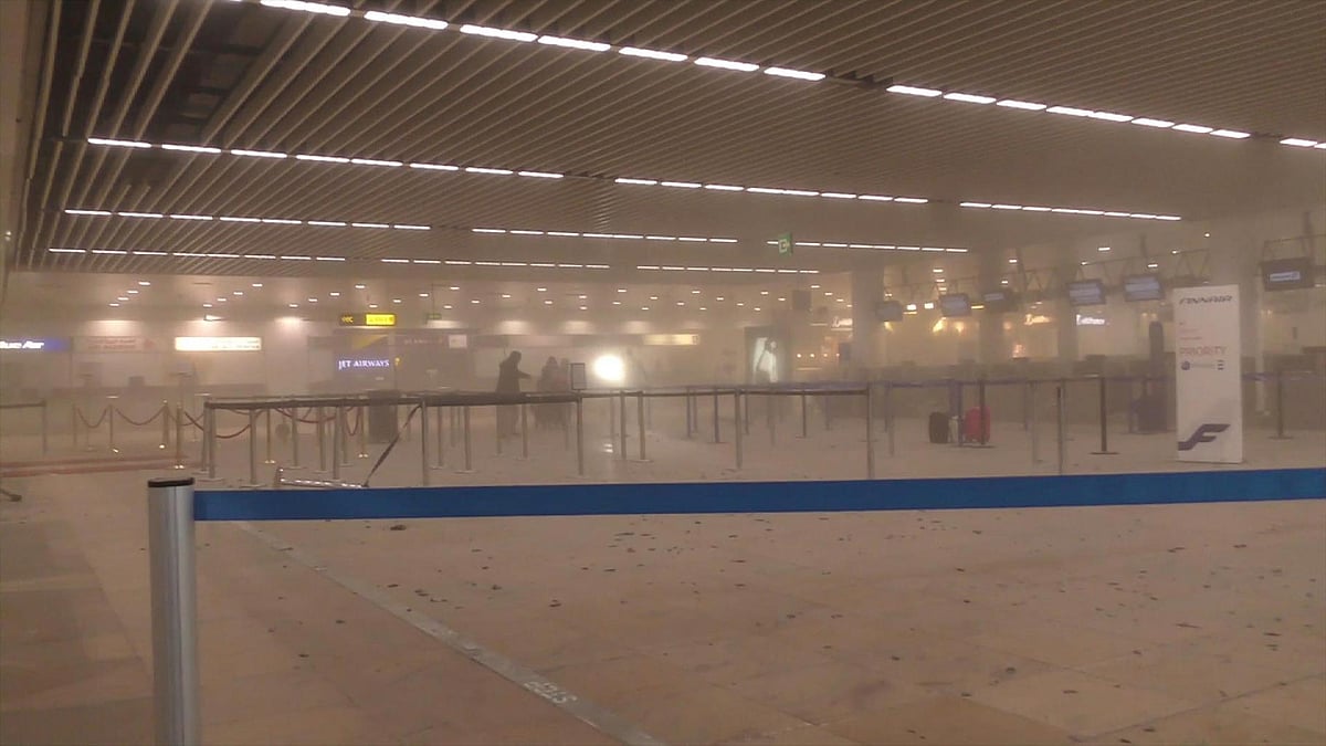 Travellers stand in a smoke-filled terminal at Brussels Airport, in Brussels after the explosions. (Photo: AP)