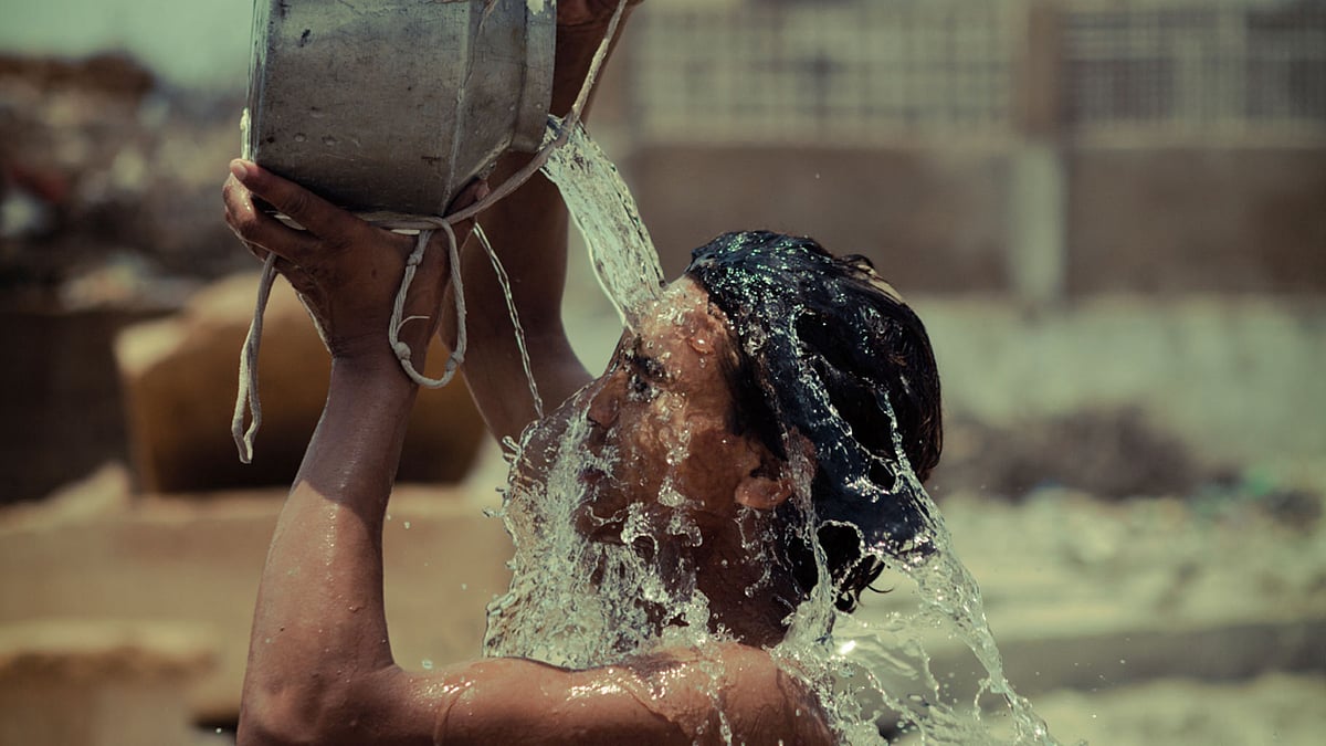 A boy splashes water on himself during a hot day. (Photo: iStockPhoto)