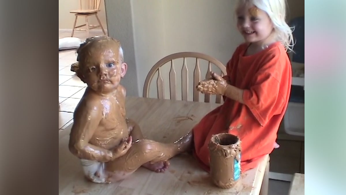 Sister flaunts her artwork by painting her baby brother with peanut butter. (Photo: AP screengrab)