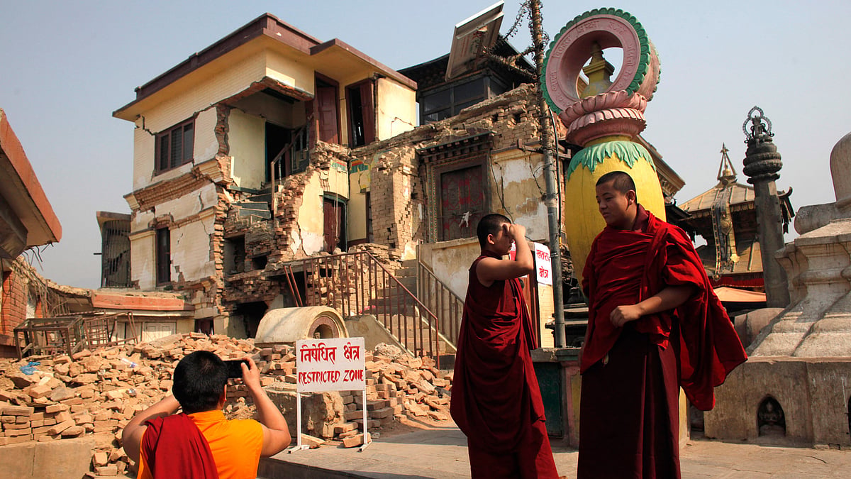 A monk takes photo of damaged monastery from last year’s earthquake in the Swayambhunath stupa, in Kathmandu, Nepal, on 25 April, 2016. (Photo: AP)
